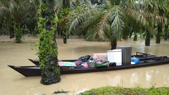 Barang milik warga Aceh Tamiang diangkut dalam perahu setelah rumahnya dilanda banjir. Foto: BPBA