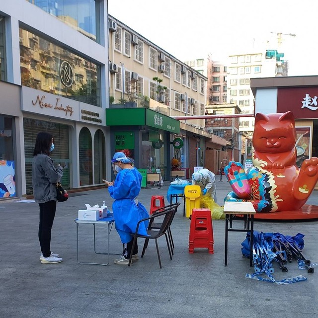 Tenaga kesehatan yang tengah menyiapkan lokasi tes PCR. Foto diambil di distrik Haizhu, kota Guangzhou, provinsi Guangdong.