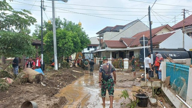 Warga bersama aparat kepolisian dan TNI bahu membahu membersihkan perumahan Wahyu Utomo, Ngaliyan Kota Semarang usai diterjang banjir bandang  Minggu (6/11) malam.  Foto: Intan Alliva/kumparan