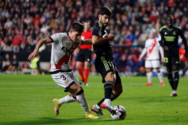 Pemail Real Madrid Marco Asensio berebut bola dengan pemain Rayo Vallecano pada pertandingan lanjutan Liga Spayol di Campo de Futbol de Vallecas, Madrid, Spanyol. Foto: Susana Vera/REUTERS