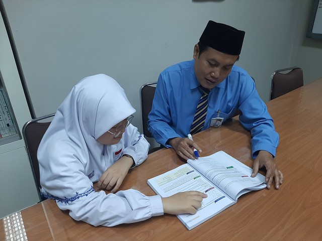 Shela bersama Imam Sibaway (guru pembina) berdiskusi mengenai soal matematika. Foto: Amanah Nur Asiah/Basra