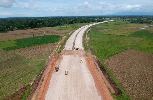 Foto udara operator alat berat menyelesaikan pembangunan jalan tol di STA 7+500 di Nagari Katapiang, Kabupaten Padangpariaman, Sumatera Barat, Selasa (8/11/2022). Foto: Iggoy el Fitra/Antara Foto
