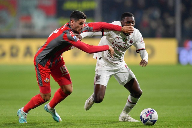 Pemain AC Milan Fode Ballo-Toure berebut bola dengan pemain Cremonese pada pertandingan lanjutan Liga Italia di Stadio Giovanni Zini, Cremona, Italia. Foto: Daniele Mascolo/REUTERS