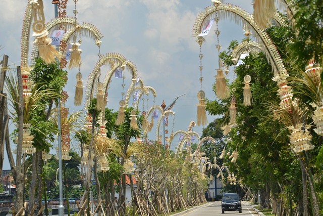 Kendaraan melintas di jalan yang pinggirnya dihiasi penjor atau hiasan janur kuning khas Bali di Jalan Tanah Kilap, Denpasar, Bali, Kamis (10/11/2022). Foto: Aditya Pradana Putra/ANTARA FOTO