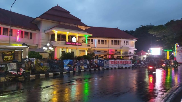 Jurnalis Malang Raya membentangkan spanduk sepanjang 37 meter berisi rangkaian foto bercerita tentang Tragedi Kanjuruhan di depan Balai Kota Malang, Kamis (10/11/2022). Foto/Azmy