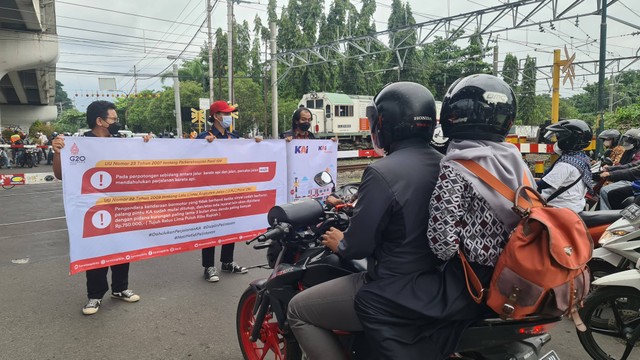 Petugas sedang melakukan sosialisasi mengenai perlintasan kereta api (KA) di Perlintasan Sebidang Stasiun Lempuyangan Yogyakarta, Kamis (10/11/2022). Foto: Sandra/Tugu Jogja