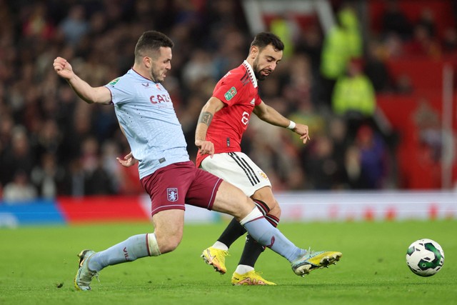 Pemain Manchester United Bruno Fernandes berebut bola dengan pemain Aston Villa Ashley Young pada pertandingan Babak Ketiga Piala Carabao di Old Trafford, Manchester, Inggris. Foto: Carl Recine/REUTERS