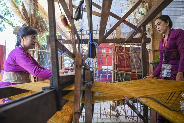 Perajin menyelesaikan pembuatan kain tenun Endek dengan menggunakan Alat Tenun Bukan Mesin (ATBM) di pusat suvenir KTT G20 di Bali Collection, kawasan ITDC, Nusa Dua, Badung, Bali, Jumat (11/11/2022). Foto: M Risyal Hidayat/ANTARA FOTO