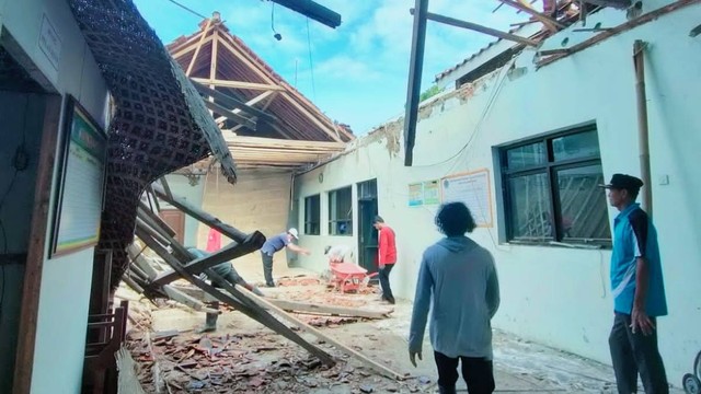 Sejumlah warga tengah membersihkan reruntuhan atap Balai Desa Dukuhwringin Kecamatan Wanasari Kabupaten Brebes.