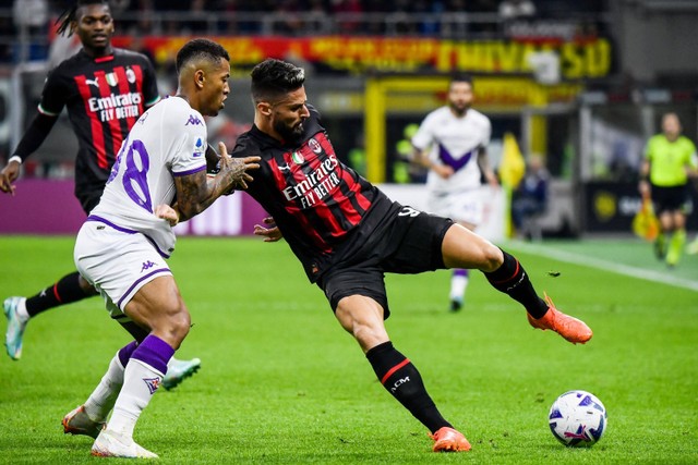 Pemain AC Milan Olivier Giroud berusaha melewati pemain Fiorentina pada pertandingan lanjutan Liga Italia di Stadion San Siro, Milan, Italia.  Foto: Filippo MONTEFORTE / AFP