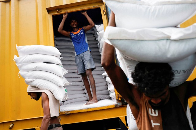 Buruh membawa karung tepung terigu di pasar utama saat Presiden Sri Lanka Ranil Wickremesinghe mengumumkan anggaran 2023 di tengah krisis ekonomi negara itu, di Kolombo, Sri Lanka, Senin (14/11/2022). Foto: Dinuka Liyanawatte/REUTERS