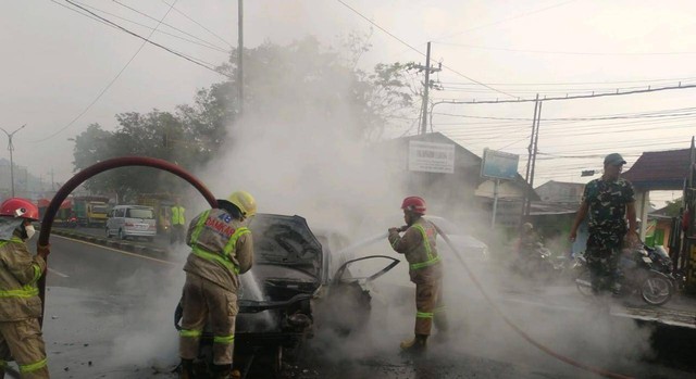 Petugas PMK Kabupaten Malang melakukan pemadaman pada mobil yang terbakar di Lawang, Kabupaten Malang. foto/PMK Kabupaten Malang