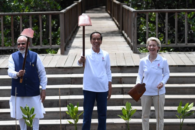 Presiden Joko Widodo (tengah) bersama Perdana Menteri India Narendra Damodardas Modi (kiri) dan Presiden Komisi Eropa Ursula von der Leyen (kanan) mengangkat cangkulnya usai menanam pohon mangrove di Taman Hutan Raya (Tahura) Ngurah Rai Bali. Foto: Akbar Nugroho Gumay/Antara Foto