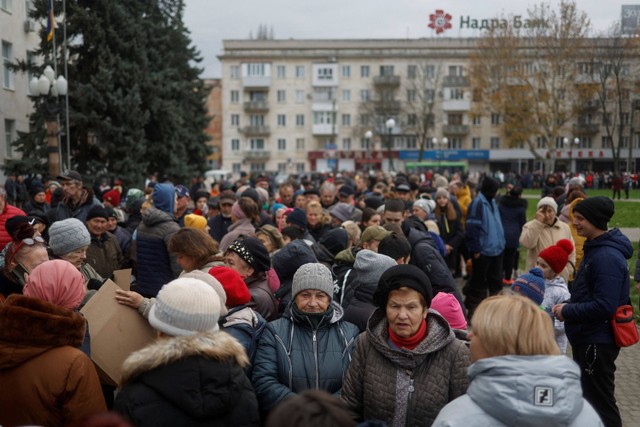 Warga mengantre di alun-alun saat mereka menunggu bantuan kemanusiaan setelah Rusia mundur dari Kherson, Ukraina. Foto: Valentyn Ogirenko/REUTERS