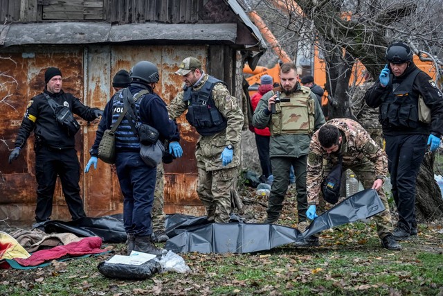 Petugas polisi memeriksa mayat yang ditemukan di bawah puing-puing rumah penduduk yang dihancurkan oleh serangan rudal Rusia, di kota Vilniansk, wilayah Zaporizhzhia, Ukraina, Kamis (17/11/2022). Foto: Stringer/REUTERS