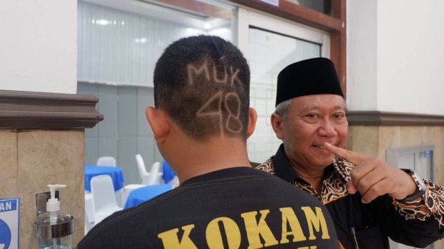 Tido Dharmawan anggota Kokam Gatak (kiri) berfoto bersama Rektor UMS Prof Sofyan Anif, Jumat (18/11). Foto: Arfiansyah Panji Purnandaru/kumparan