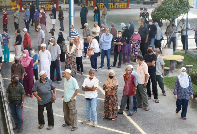 Orang-orang mengantri untuk memberikan suara mereka selama pemilihan umum di Permatang Pauh, Penang, Malaysia, Sabtu (19/11/2022). Foto: Hasnoor Hussain/Reuters