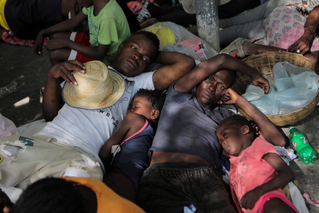 Orang-orang yang terlantar akibat kekerasan perang geng di Cite Soleil, beristirahat di jalan lingkungan Delmas setelah meninggalkan alun-alun Hugo Chaves di Port-au-Prince, Haiti, Sabtu (19/11/2022). Foto: Ralph Tedy Erol/REUTERS