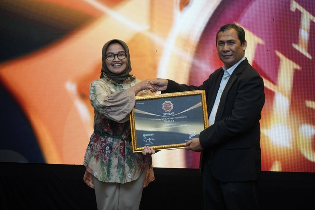 Tutut Wijayanti selaku Regulatory Affairs Manager, PT Unilever Indonesia, Tbk. menerima Top Halal Award 2022 yang diserahkan oleh Anang Ghozali, Head of IHATEC Marketing Research. Foto: Wall's