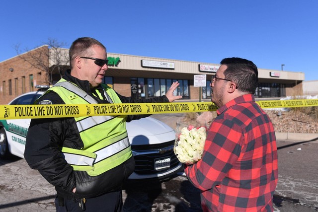 Petugas polisi berbicara dengan warga di dekat Club Q, lokasi penembakan massal di Colorado Springs, Colorado, Minggu (20/11/2022). Foto: Jason Connolly/AFP