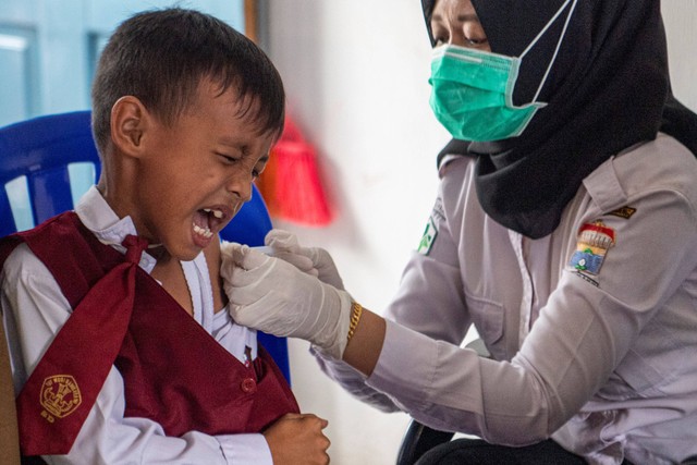 Petugas kesehatan dari Puskesmas Kampus Palembang menyuntikkan vaksin di SD Negeri 21 Palembang, Sumatera Selatan, Senin (21/11/2022).  Foto: Nova Wahyudi/ANTARA FOTO