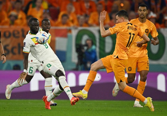 Cheikhou Kouyate dari Senegal duel dengan Steven Berghuis dari Belanda pada pertandingan Grup A Piala Dunia 2022 Qatar di Stadion Al Thumama, Doha, Qatar. Foto: Dylan Martinez/Reuters