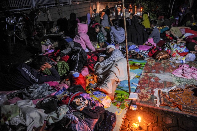 Warga mengungsi di halaman rumah karena khawatir adanya gempa susulan di Kampung Cijedil, Kabupaten Cianjur, Jawa Barat, Senin (21/11/2022). Foto: Raisan Al Farisi/Antara Foto