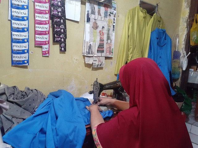 Bu Nur ketika sedang menjahit baju milik pelanggan (sumber : foto sendiri)