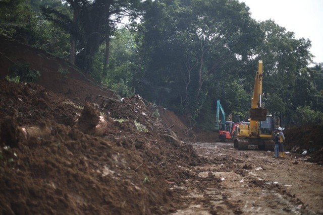 Petugas gabungan berusaha mengevakuasi sejumlah kendaraan yang terdorong ke jurang akibat longsoran di kawasan Cugenang, Cianjur, Jawa barat, Selasa (22/11). Foto: Aditia Noviansyah/kumparan