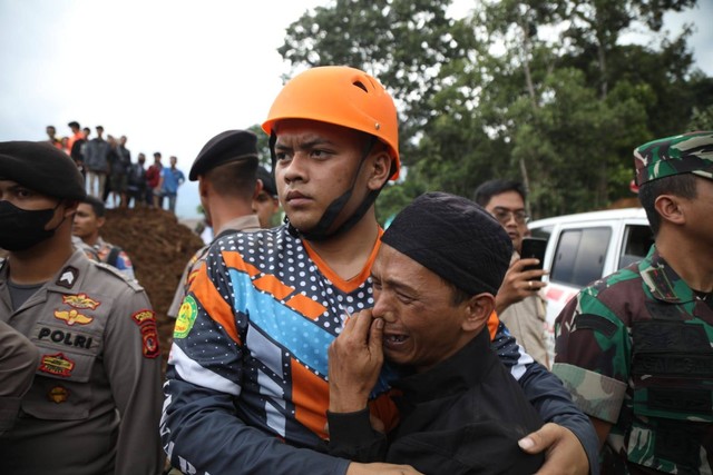 Deden menangis usai petugas menemukan istri dan anaknya yang tertimbun longsor akibat gempa di Cugenang, Cianjur, Selasa (22/11/2022).  Foto: Aditia Noviansyah/kumparan