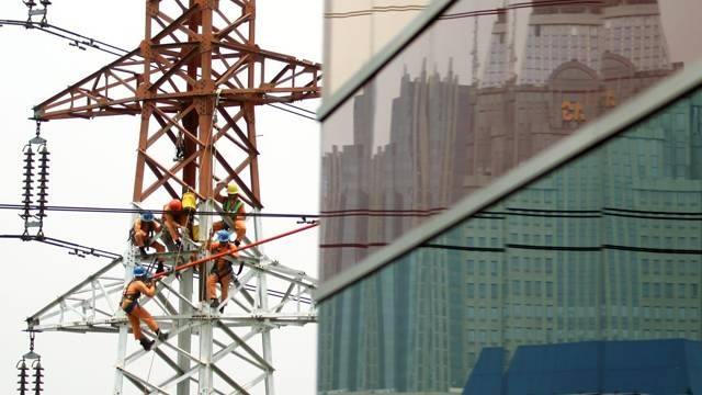 Pekerja PLN sementara bekerja di salah satu tower listrik.