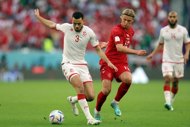 Pemain Timnas Denmark Kasper Dolberg berebut bola dengan pemain Timnas Tunisia Montassar Talbi pada pertandingan Grup D Piala Dunia 2022 Qatar di Education City Stadium, Al Rayyan, Qatar. Foto: Matthew Childs/REUTERS