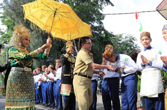 Pj Walkot Banda Aceh Bakri Siddiq menyalami pelajar saat tiba di SMP Negeri 19 Percontohan Kota Banda Aceh untuk membuka Festival Ceudah, Selasa (22/11). Foto: Humas Banda Aceh