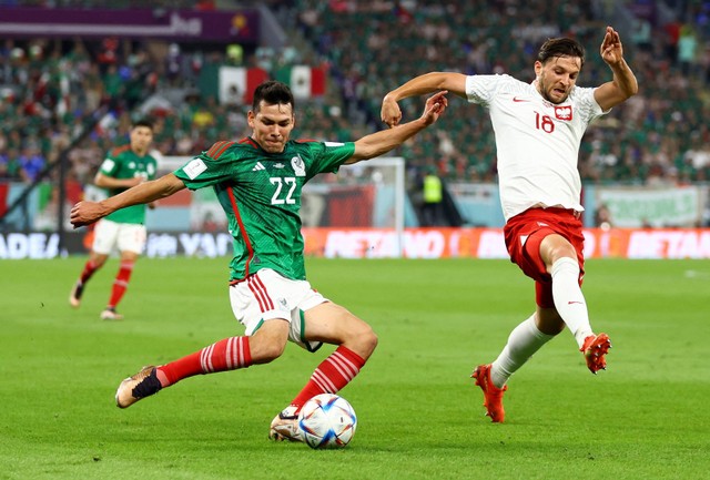 Hirving Lozano dari Meksiko duel dengan Bartosz Bereszynski dari Polandia pada pertandingan Piala Dunia Qatar Grup C di Stadium 974, Doha, Qatar. Foto: Hannah McKay/Reuters