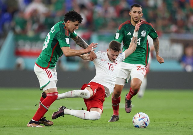 Jorge Sanchez dari Meksiko duel dengan Sebastian Szymanski dari Polandia pada pertandingan Piala Dunia Qatar Grup C di Stadium 974, Doha, Qatar. Foto: Carl Recine/Reuters