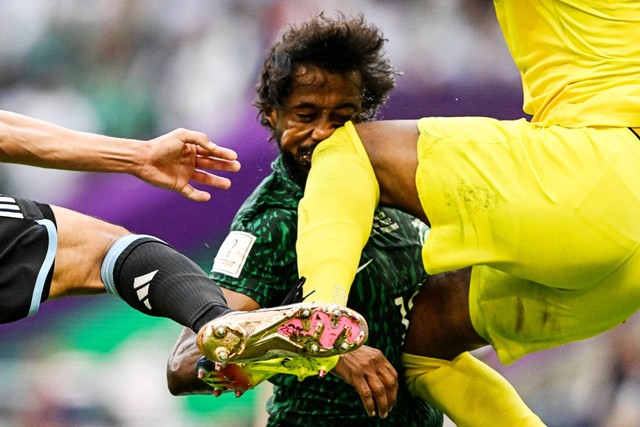 Pemain Arab Saudi Yasser Al-Shahrani terkena dengkul kiper Mohammed Al-Owais saat hadapi Argentina pada Piala Dunia 2022 Qatar di Stadion Lusail, Lusail, Qatar, Selasa (22/11/2022). Foto: Kirill Kudryavtsev/AFP