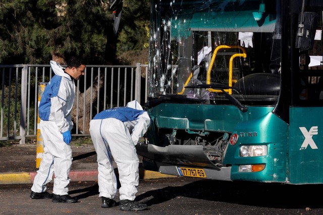 Polisi Israel memeriksa bus yang rusak setelah ledakan di halte bus di Yerusalem, Rabu (23/11/2022). Foto: Ammar Awad/REUTERS
