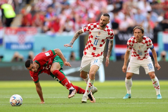 Pemain Timnas Kroasia Marcelo Brozovic  berebut bola dengan pemain Timnas Maroko Selim Amallah pada pertandingan Grup F Piala Dunia 2022 Qatar di Stadion Al Bayt, Al Khor, Qatar.  Foto: Carl Recine/REUTERS