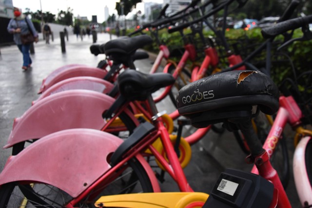 Pekerja melintas di dekat sepeda "Gowes" yang terparkir di kawasan Jalan Jenderal Sudirman, Jakarta, Rabu (23/11/2022). Foto: Indrianto Eko Suwarso/Antara Foto