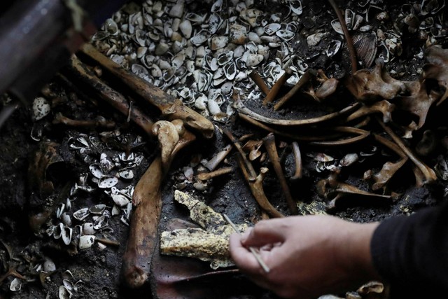 Seorang arkeolog menggali persembahan ritual suku Aztec yang ditemukan tepat di tengah platform melingkar seremonial yang penting, tak jauh dari tangga Templo Mayor, kuil paling suci kekaisaran Aztec, di Mexico City, Meksiko, 15 November 2022. Foto: Henry Romero/REUTERS