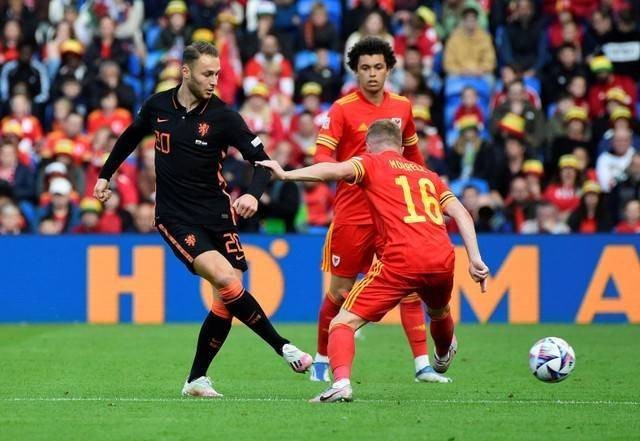 Pemain Belanda Teun Koopmeiners duel dengan Joe Morrell dari Wales saat pertandingan UEFA Nations League di Stadion Cardiff City, Cardiff, Wales, Inggris, Rabu (8/6/2022). Foto: Rebecca Naden/Reuters