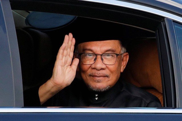 Perdana Menteri baru Malaysia Anwar Ibrahim melambai kepada fotografer saat ia tiba di Istana Nasional di Kuala Lumpur, Malaysia 24 November 2022. Foto: Fazry Ismail/Pool via REUTERS