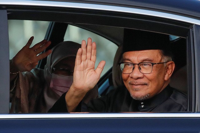 Perdana Menteri baru Malaysia Anwar Ibrahim melambai kepada fotografer saat ia tiba di Istana Nasional di Kuala Lumpur, Malaysia 24 November 2022. Foto: Fazry Ismail/Pool via REUTERS