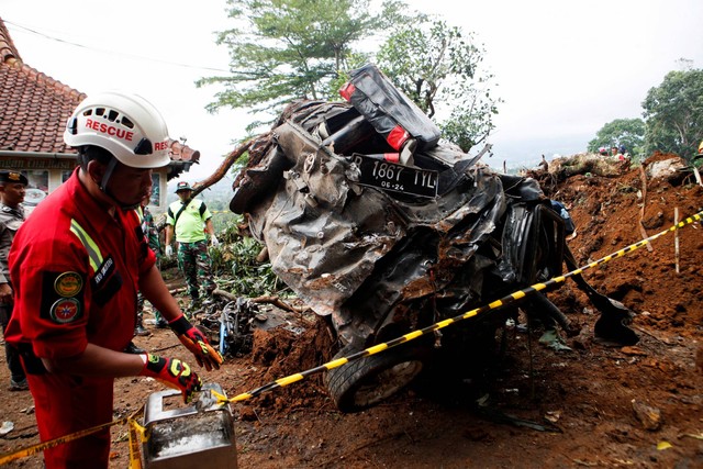 Petugas mengevakuasi mobil yang tertimbun longsor akibat gempa di Cugenang, Kabupaten Cianjur, Jawa Barat, Kamis (24/11/2022). Foto: Ajeng Dinar Ulfiana/REUTERS