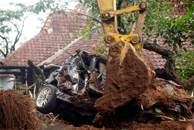 Petugas SAR mengunakan alat berat melakukan evakuasi mobil yang tertimbun longsor akibat gempa di Cugenang, Kabupaten Cianjur, Jawa Barat, Kamis (24/11/2022). Foto: Yulius Satria Wijaya/ANTARA FOTO