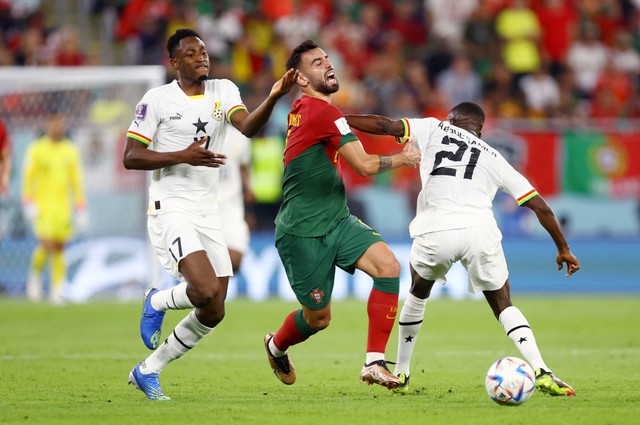 Bruno Fernandes dari Portugal duel dengan Salis Abdul Samed dan Abdul Rahman Baba dari Ghana pada pertandingan Piala Dunia Qatar 2022 Grup H di Stadion 974, Doha, Qatar. Foto: Hannah Mckay/Reuters 