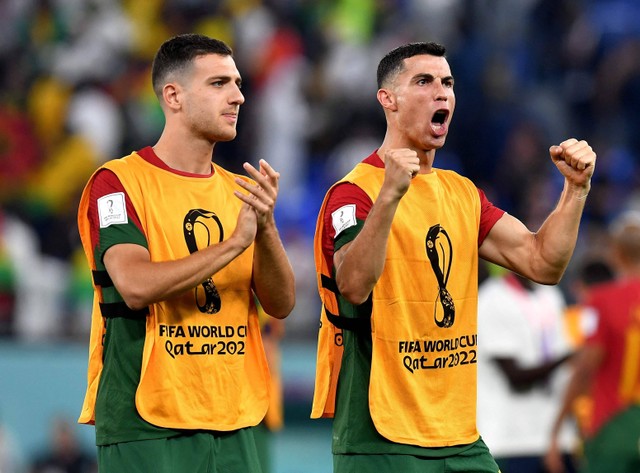 Diogo Dalot Portugal dan Cristiano Ronaldo merayakan setelah pertandingan Piala Dunia Qatar 2022 Grup H di Stadion 974, Doha, Qatar. Foto: Jennifer Lorenzini/Reuters