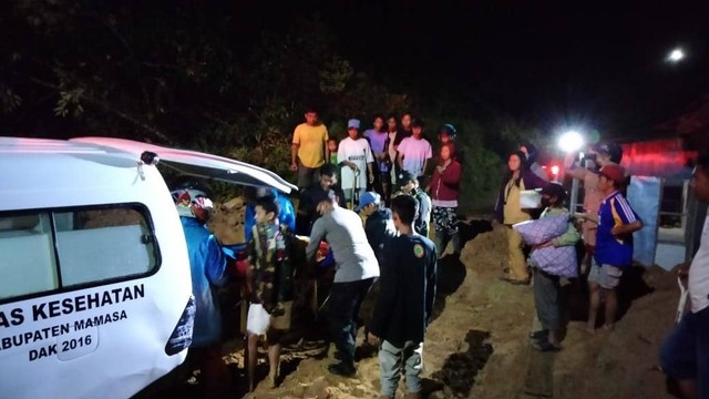 Polisi bersama warga mengevakuasi seorang wanita hamil yang terhalang longsor di ruas Jalan Mamasa-Polewali. Foto: Dokumentasi Polsek Sumarorong