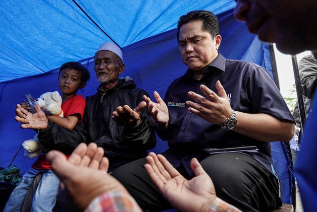 Menteri BUMN Erick Thohir (kanan) berdoa bersama warga saat meninjau posko bencana Satgas BUMN di Limabangansari, Cianjur, Jawa Barat, Jumat (25/11/2022). Foto: Dhemas Reviyanto/ANTARA FOTO
