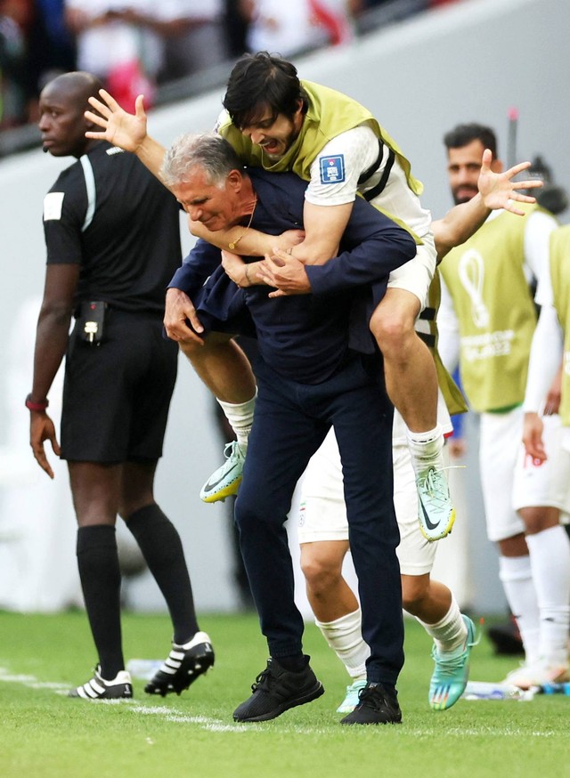 Pemain Iran Sardar Azmoun merayakan dengan pelatih Iran Carlos Queiroz setelah pertandingan usai Wales pada Piala Dunia FIFA Qatar 2022 di Stadion Ahmad Bin Ali, Al Rayyan, Qatar, Jumat (25/11/2022). Foto: Carl Recine/REUTERS